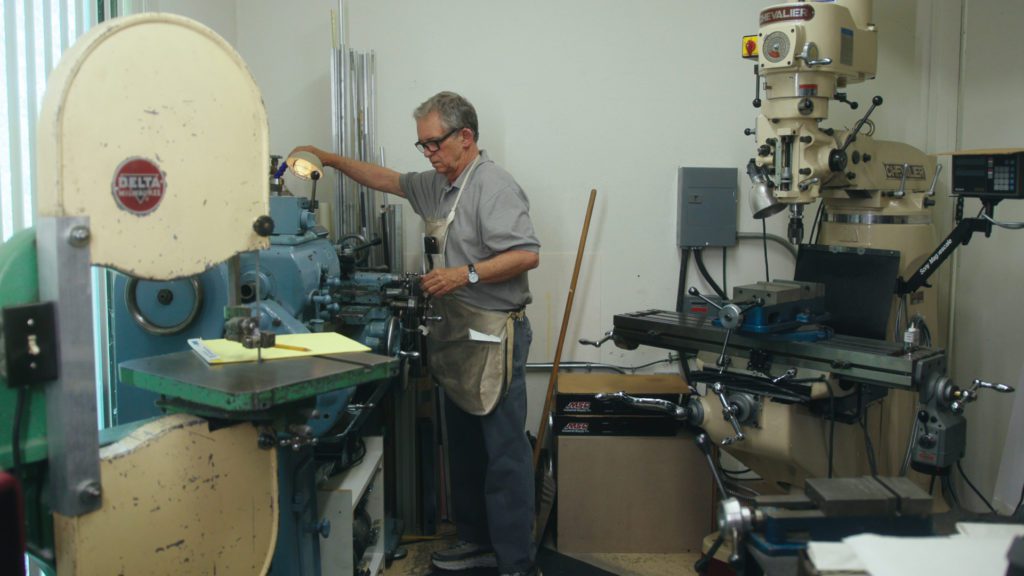 Modern inventor Paul Kirby working in his machine shop creating parts for painting robot Dulcinea